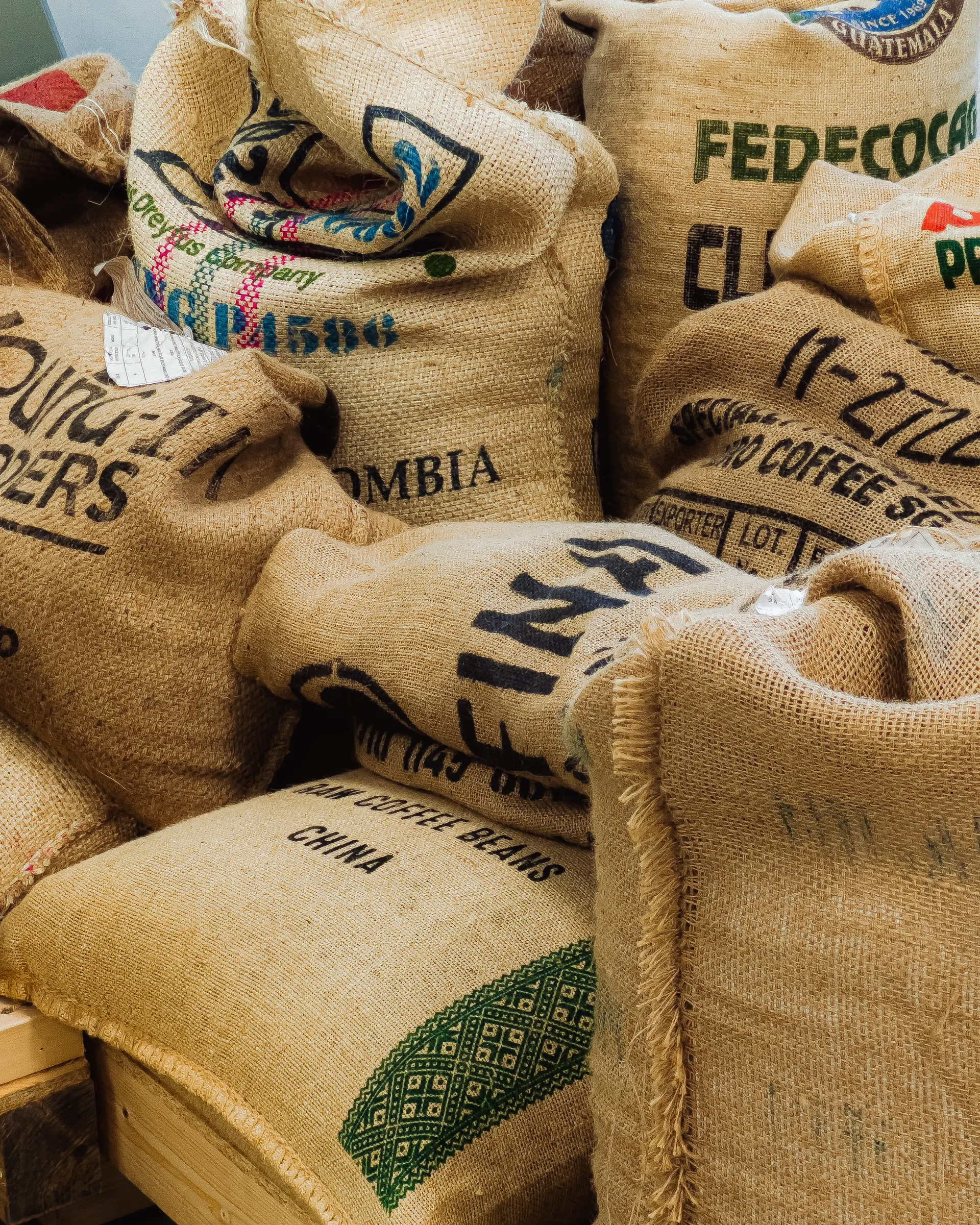 Stacked burlap sacks stamped with coffee origins from around the world